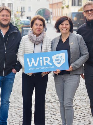 Operativer Vorstand der WiR Alpbachtal | © WiR Alpbachtal Der operative Vorstand der WiR Alpbachtal, zwei Männer und zwei Frauen, stehen gemeinsam im Stadtzentrum von Rattenberg und halten ein blaues Schild mit der Aufschrift "WiR Alpbachtal" in den Händen. | © WiR Alpbachtal