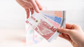 WiR-Gutscheine mit neuem Design | © WiR Alpbachtal | Genusskind Nahaufnahme von zwei Händen, die gemeinsam WiR-Gutscheine halten. | © WiR Alpbachtal | Genusskind
